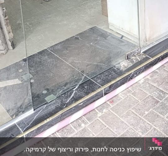 עבודת ריצוף מפתן כניסה באריחים כהים לצד דלת זכוכית